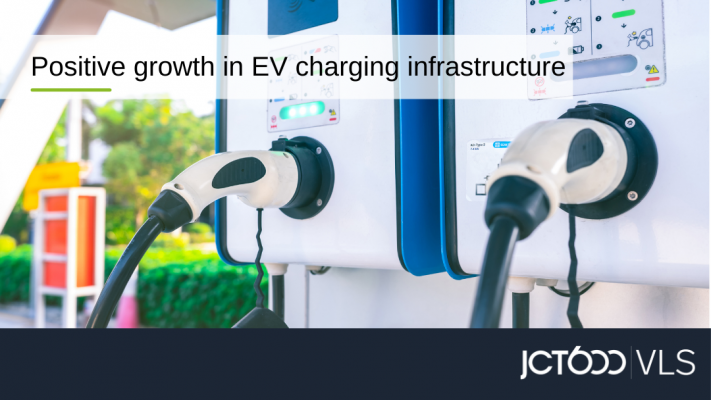White overlay text box that says "positive growth in EV charging infrastructure - over an image of a 2 white and blue charging units side by side as a close up shot, and a bottom blue banner with the jct600 vls logo in it in white